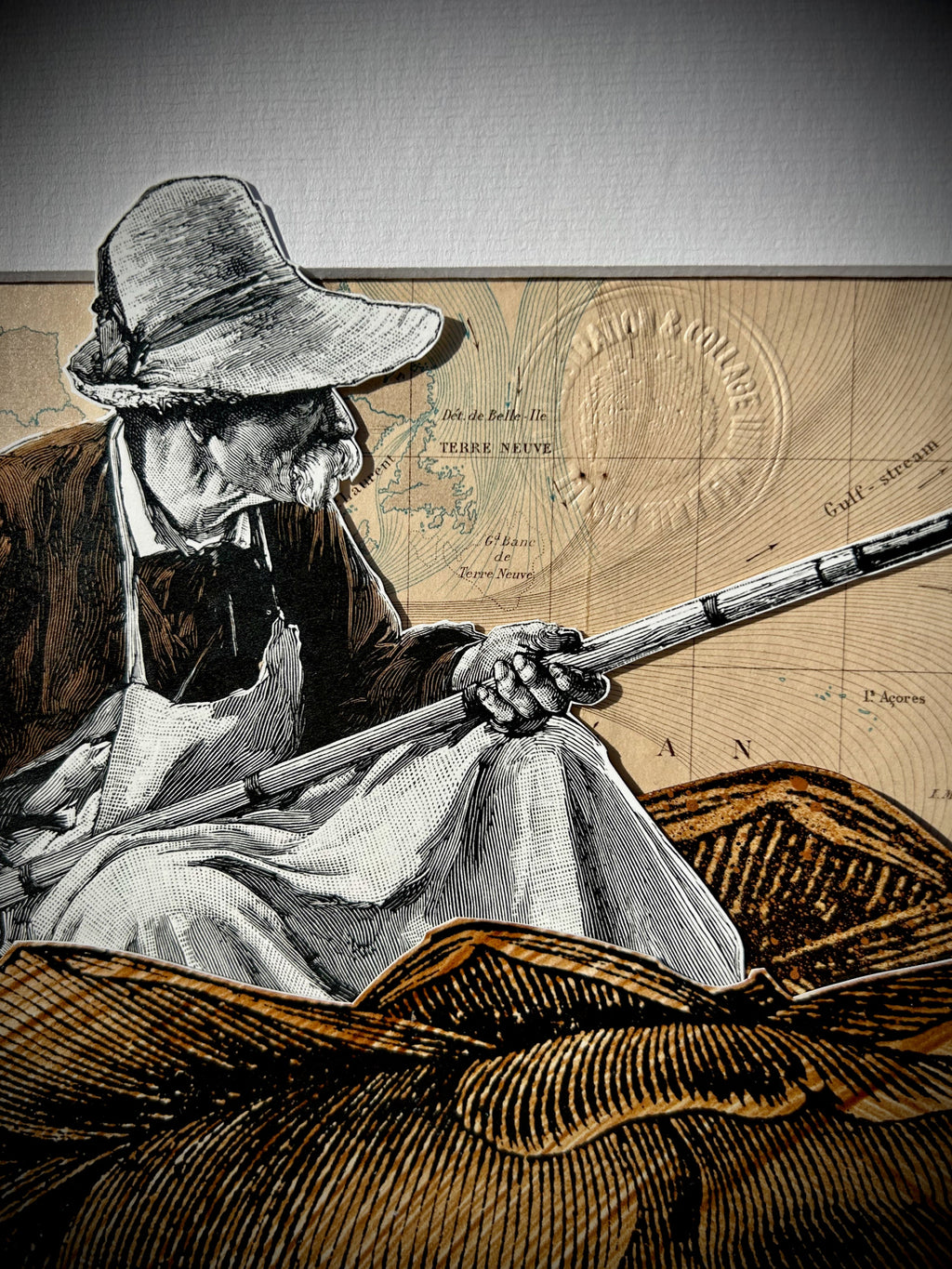 (gros plan sur l'œuvre sans cadre) : "Fisherman" collage, zoom sur le pêcheur et la carte d'époque, papiers anciens et papiers gravures teintés au brou de noix, 30x40 cm, signé Mélanie Busnel