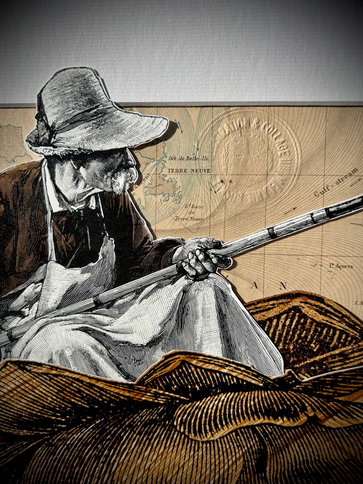 (gros plan sur l'œuvre sans cadre) : "Fisherman" collage, zoom sur le pêcheur et la carte d'époque, papiers anciens et papiers gravures teintés au brou de noix, 30x40 cm, signé Mélanie Busnel